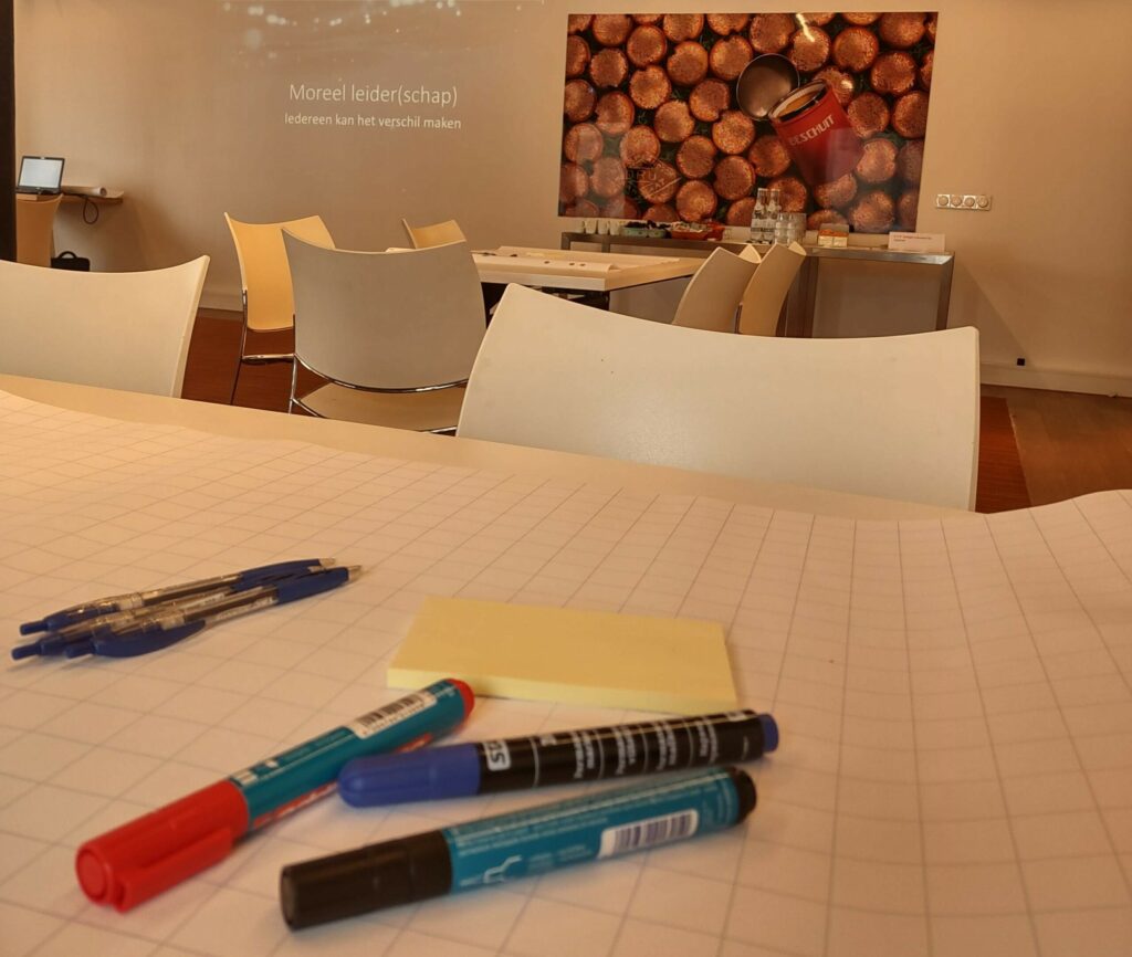 Gathering markers, paper, and pens as preparation for an interactive training on moral deliberation
